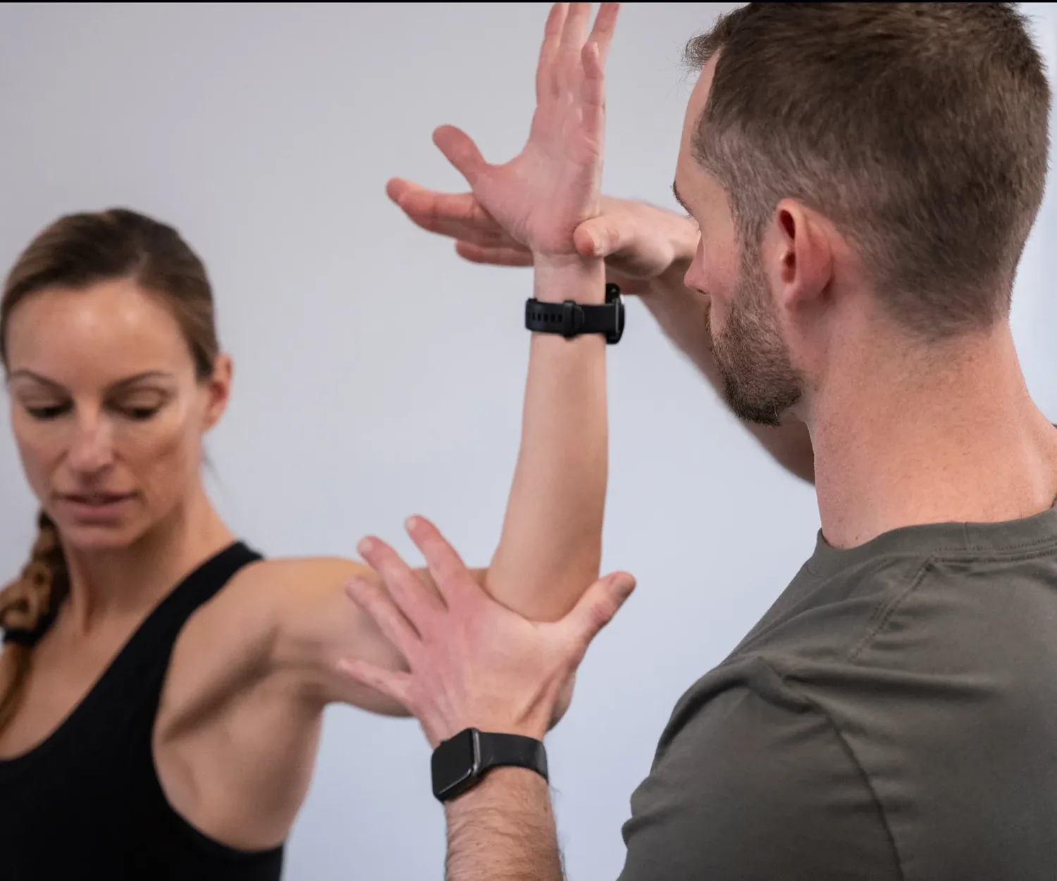 A Fullswift physical therapist performing a hands-on shoulder assessment on an athlete